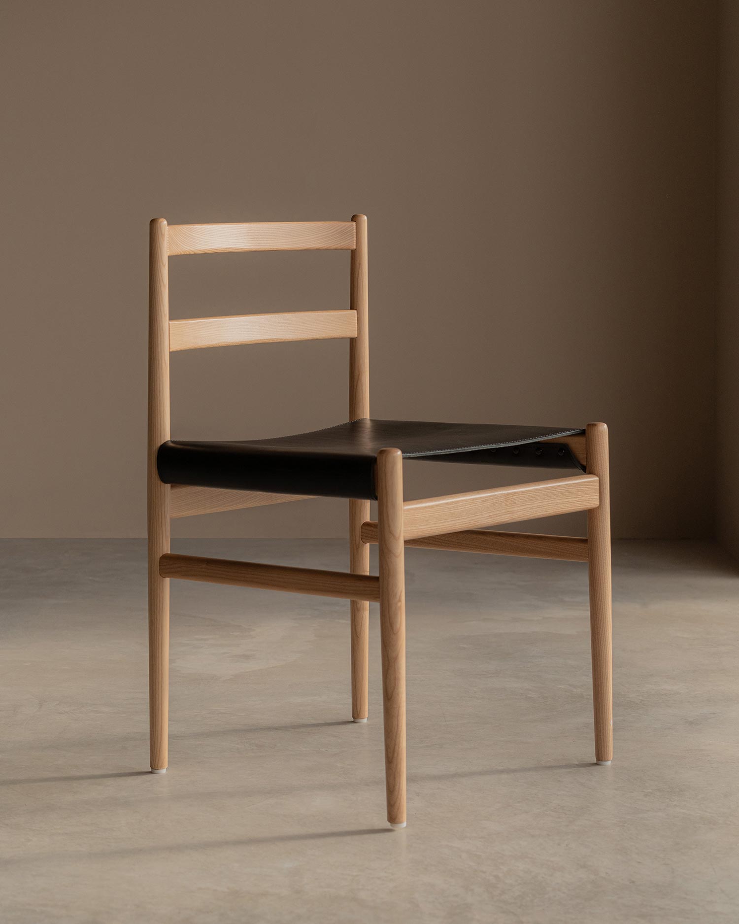 Pack de 2 sillas Velera con estructura de madera maciza de fresno con acabado natural y tapizado en cuero negro