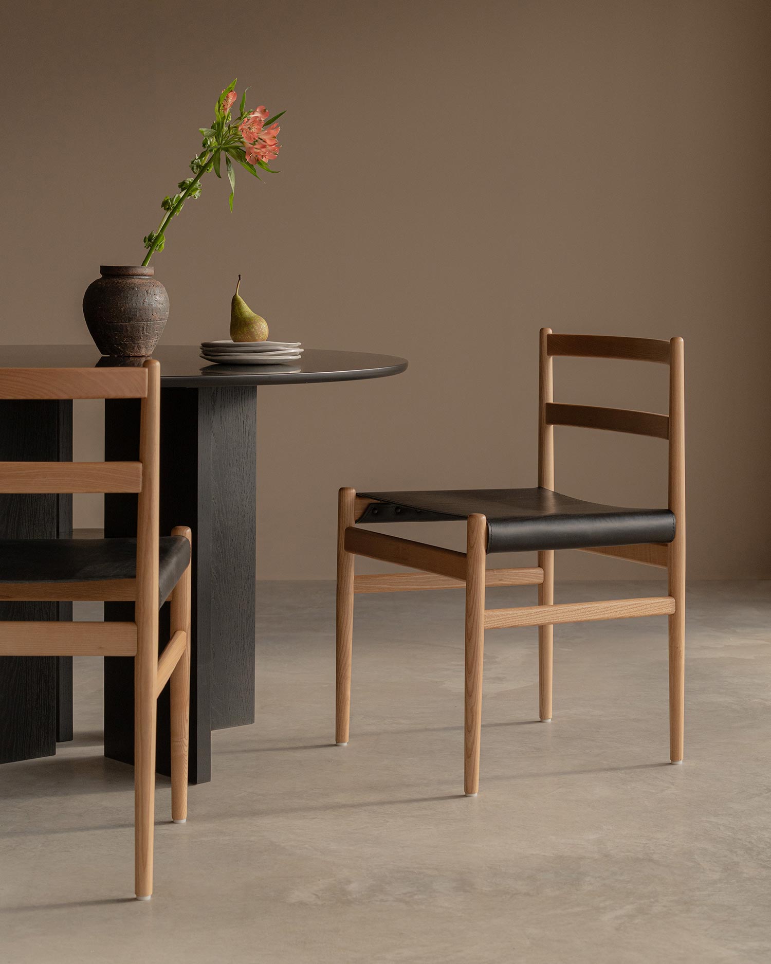 Pack de 2 sillas Velera con estructura de madera maciza de fresno con acabado natural y tapizado en cuero negro