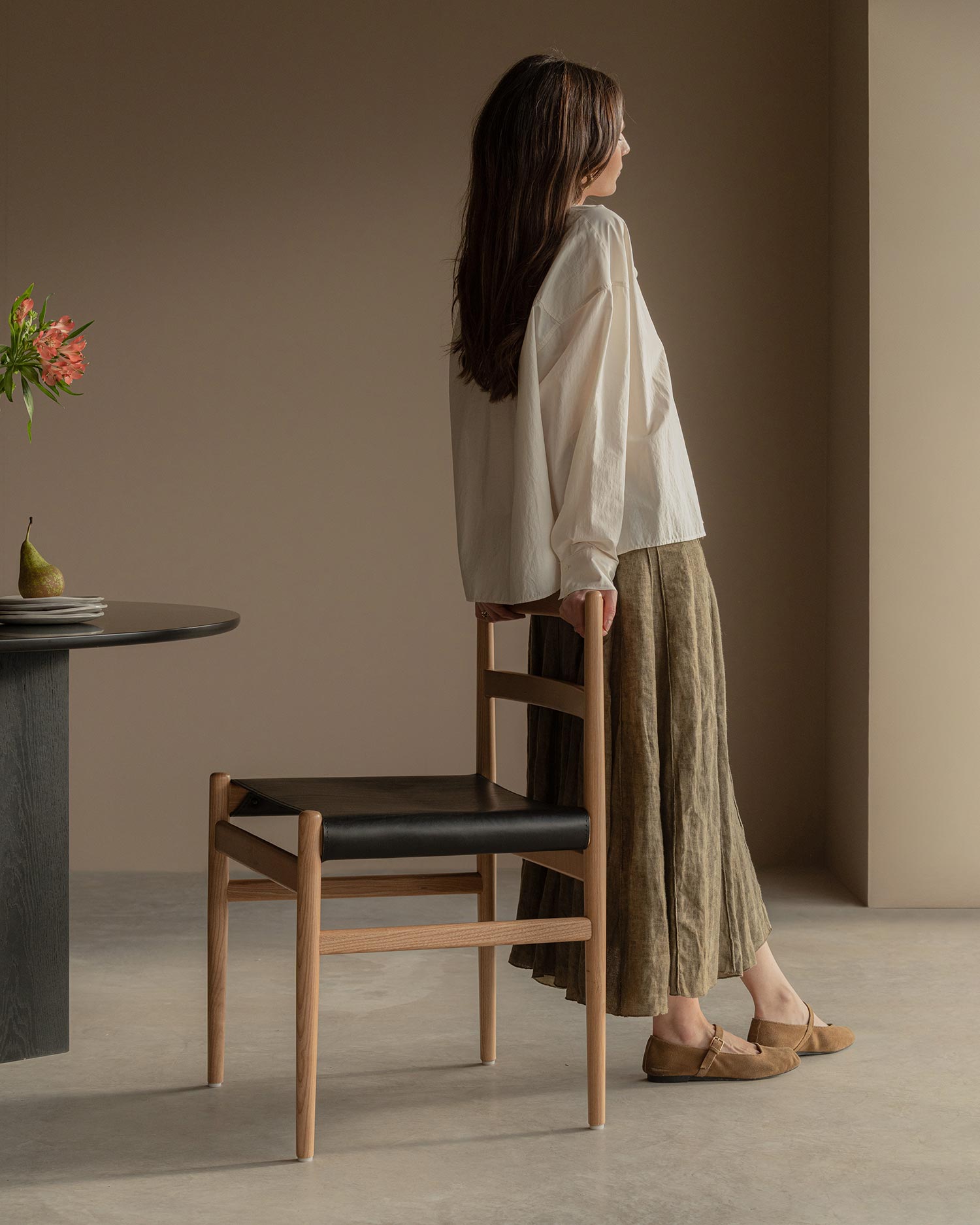 Silla Velera con estructura de madera maciza de fresno con acabado natural y tapizado en cuero negro